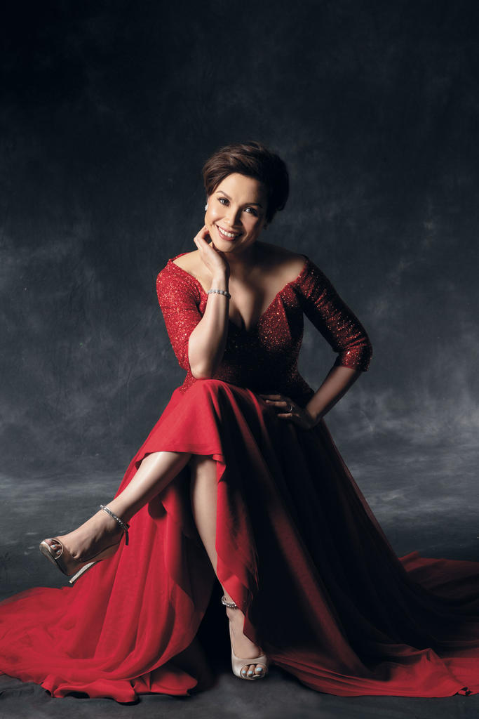 Lea Salonga sitting in a red dress