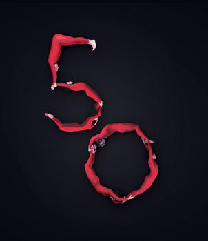 Dancers wearing red unitards form he numbers "50" on a black background.